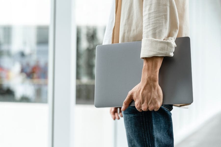 Person carrying laptop, symbolising flexible modern work and freedom to work anywhere.
